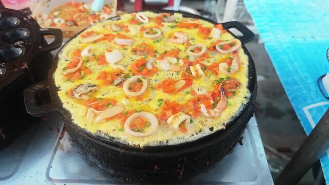 Seafood Egg Mortar using giant pan fried clams, delicious street food in Thailand.