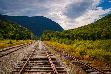Fototapeta premium Scenic railroad tracks at Crawford Notch Depot running through White Mountain National Forest in Benton Woods and Carroll, New Hampshire, USA