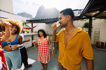 Group of friends enjoying outdoor rooftop drinks and celebration under the sun