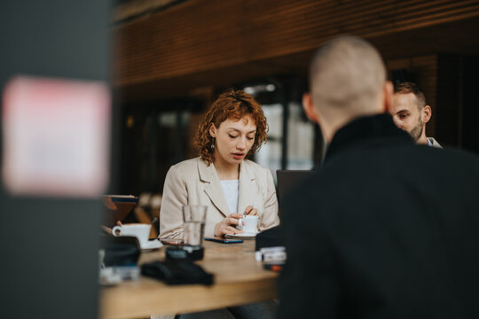 A small group of business professionals having a meeting outdoors, sharing ideas, and working together. The scene captures collaboration and teamwork in a contemporary and casual office-like setting.