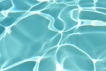 Relaxing in swimming pool. Swimming pool blue water reflecting the sun rippled details. Patterns of movement of water in the pool. Summer background. Water movement background. Banner with copy space.