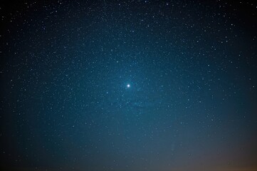 Obraz premium A vast dark blue night sky adorned with countless stars and one luminous celestial object.