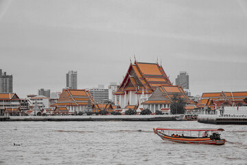 Obraz premium Bangkok, Thailand - December 9, 2024 : Chao Phraya river view of Bangkok, Thailand's Wat Arun. The Buddhist temple is a well-known tourist destination in Thailand and a landmark in Bangkok.