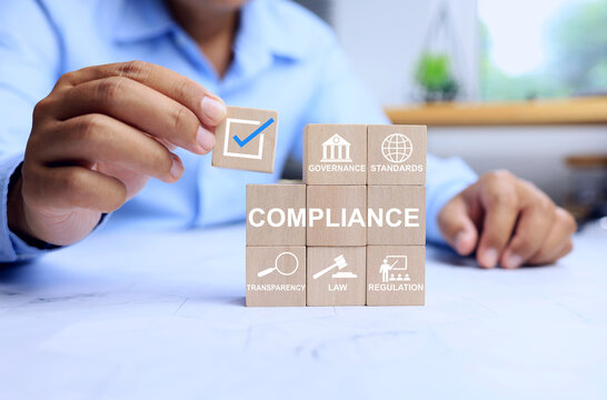 Compliance concept with businessman arrange wooden block on working table represent to applied standard and regulation to meet requirement