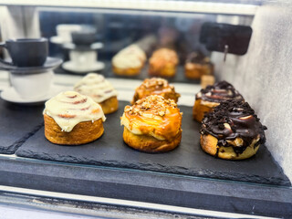 Sweet rolls with icing and chocolate in a bakery counter. Dessert, indulgence and sweet culinary...