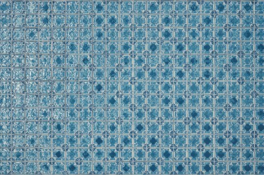 Intricate design of tiny blue and white tiles arranged in a balanced formation similar to a pool floor