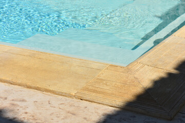 Relaxing in swimming pool. Swimming pool blue water reflecting the sun rippled details. Patterns of movement of water in the pool. Summer background. Water movement background. Water background.