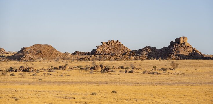 Barren landscape with hills of stacked rocks, desert landscape in the evening light at sunset, Erongo, Damaraland, Namibia