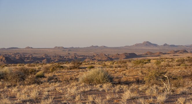 Desert landscape in the evening light at sunset, barren landscape with hills of stacked rocks, Erongo, Damaraland, Namibia