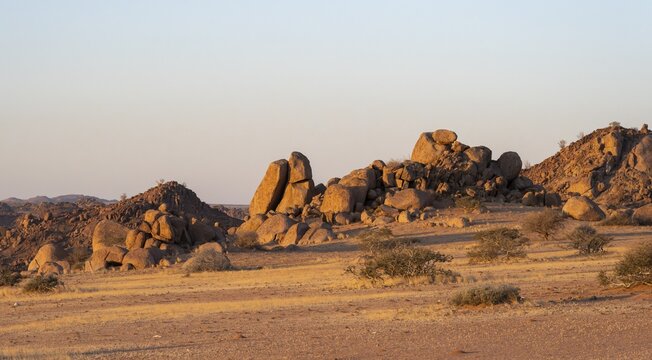 Barren landscape with hills of stacked rocks, desert landscape in the evening light at sunset, Erongo, Damaraland, Namibia