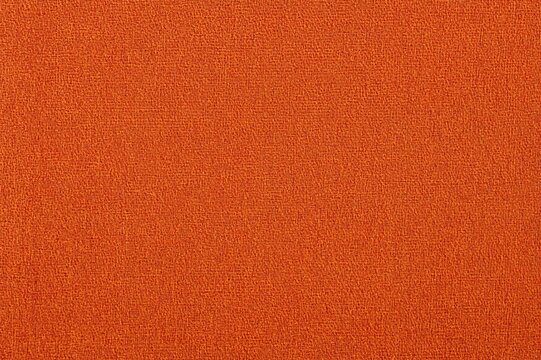 Close-up of textured orange jacquard upholstery fabric with coarse weave