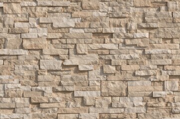 Fototapeta premium Rustic ceramic wall tiles in natural beige and brown tones for exterior use, featuring a brick wall background and varied floor tile patterns, ideal for garden paving and parking spaces.