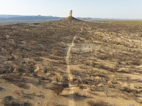 The Vingerklip (rock finger) is surrounded by thornbush and mopane (Colophospermum mopane) savanna. Aerial view. Drone shot. Damaraland, Namibia