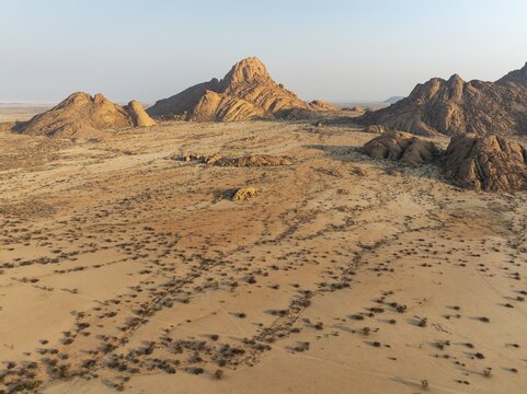 The isolated Spitzkoppe mountain (1728 m) majestically rises above the surrounding desert plains. Aerial view. Drone shot. Damaraland, Namibia