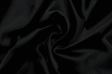 Fototapeta premium Close-up of a gently wrinkled dark fabric with a soft shine, ideal as an elegant backdrop for a moody and alluring theme.
