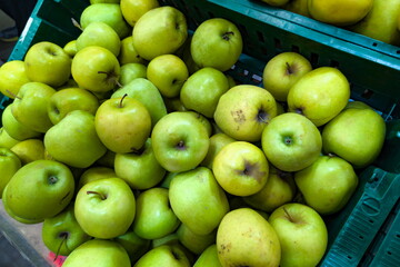 Fresh green apples piled in baskets at a local market during the afternoon