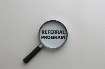 Referral program text magnified on a gray surface, conceptual design, empty space