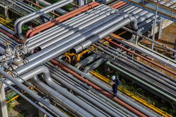 Male worker inspection at steel long pipes and pipe elbow in station oil factory during refinery valve of visual check record pipeline
