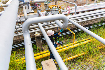 Male worker inspection and measurement thickness pipeline oil and gas at check record pipeline