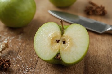 Close-up view of a halved green apple sliced with a blade