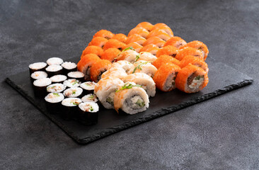 A Beautiful and Colorful Sushi Platter Arranged Creatively on a Slate Serving Board