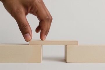 Hand positioning a wooden toy to connect two sides, symbolizing problem-solving