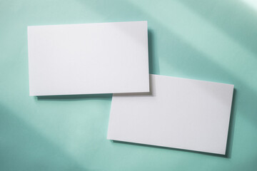 Empty white blank greeting or invitation card on blue background. Mock up presentation.