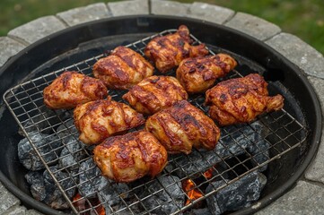 Grilled chicken cooked over a charcoal fire, prepared for serving.