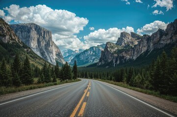 Fototapeta premium Paved highway through a mountainous natural setting beneath a clear blue sky