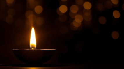 Golden diya glowing in darkness, symbolizing tradition and festive spirit in Indian culture.