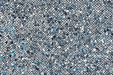 Silver square sequins sparkling with rainbow reflections including blue, gray, green, black, red, yellow and others. Textures and Backgrounds.