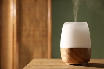 One stylish aroma lamp on wooden table indoors, closeup. Space for text
