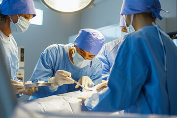 A group of surgeons are performing a surgery on a patient. Scene is serious and focused, as the surgeons are working together to save the patient's life.