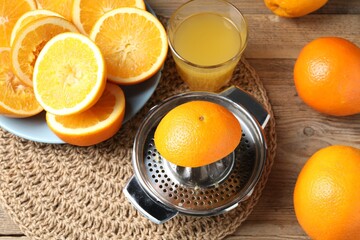 Freshly squeezed orange juice, fruits and juicer on wooden table, above view