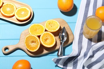Squeezer, oranges and fresh juice on blue wooden table, above view