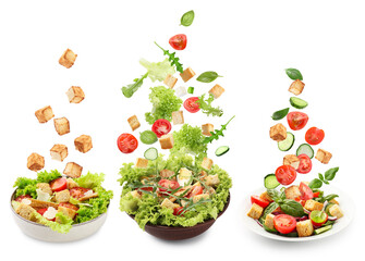 Croutons and other ingredients falling into bowls of salads against white background, set