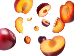 Fresh ripe plums swirling in air against white background