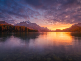 Nature. Mountain lake at dawn. Bright sky and clouds. Reflections on the water surface. Incredible view of the mountain valley. Photo for background, wallpaper, postcards.