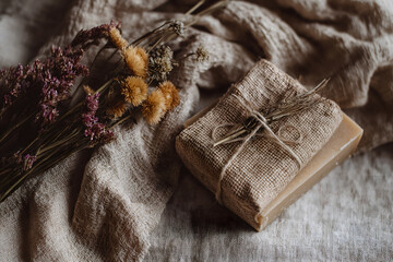 Fototapeta premium Handcrafted soap rests with dried herbs on linen, evoking sense of natural beauty and simple pleasures