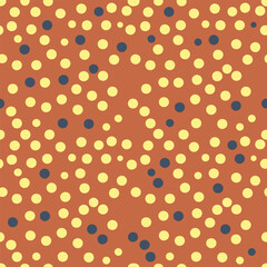 Seamless polka dot pattern with yellow and blue circles on a warm terracotta background creating a fun and retro aesthetic