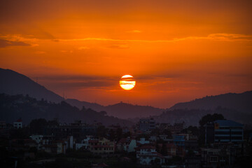 Fototapeta premium Sunset Over the Cityscape and Hills