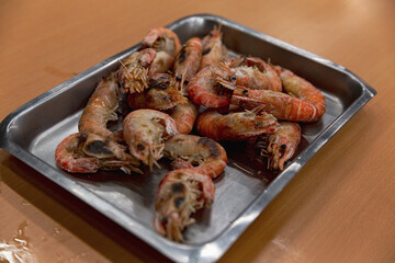 Freshly grilled shrimp arranged in a metal tray, served hot at a Taiwanese shrimp fishing venue as part of DIY salt grilled shrimp experience