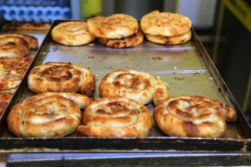 Albanian cuisine. Typical breakfast or street food - byrek pastry in bakery. Stuffed pastry made of flaky filo dough.