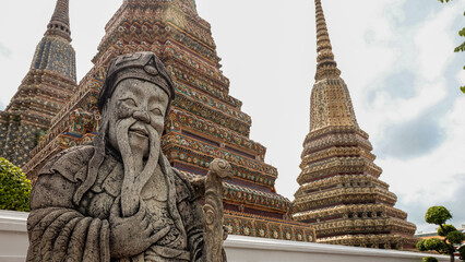 Stone Guardian Statue with Colorful Buddhist Stupas in Traditional Temple Courtyard