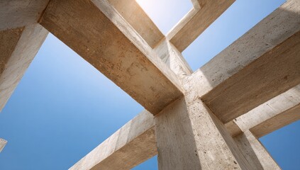 Fototapeta premium Concrete support beams crisscross against a vibrant blue sky