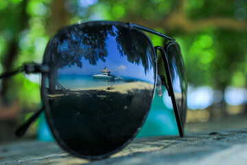 Tropical Beach Reflected in Sunglasses with Boat and Ocean View
