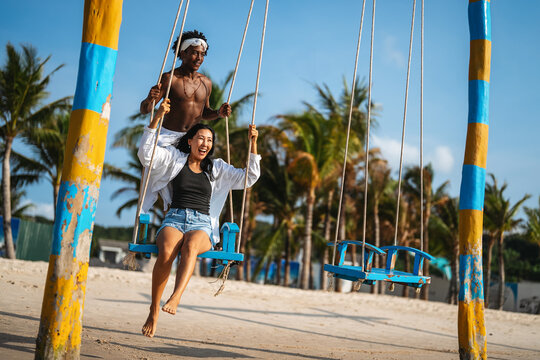 Interracial couple enjoying a romantic beach getaway, embracing love, laughter, and togetherness - Powered by Adobe