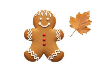 A whimsical gingerbread man cookie, decorated with white icing and red sprinkles, sits beside a dried autumn leaf against a black backdrop.