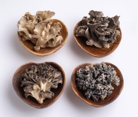 Four small, shallow, wooden bowls hold different varieties of dried mushrooms.  Light beige, dark gray, and dark brown, their textures are slightly rough and irregular