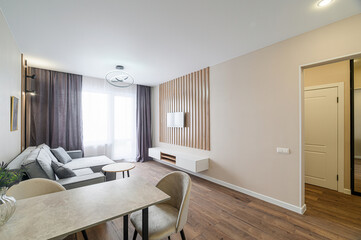 Modern living room with sofa, wooden accents, and neutral color palette. Clean and stylish design